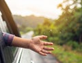 A close-up of a hand reaching out from a car window, with raindrops on the glass. Royalty Free Stock Photo