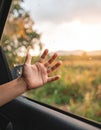 A close-up of a hand reaching out from a car window, with raindrops on the glass. Royalty Free Stock Photo