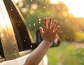 A close-up of a hand reaching out from a car window, with raindrops on the glass. Royalty Free Stock Photo