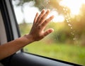 A close-up of a hand reaching out from a car window, with raindrops on the glass. Royalty Free Stock Photo