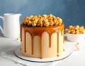 Delicious homemade cake with caramel sauce and popcorn on table against color background Royalty Free Stock Photo