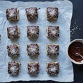 Twelve small square cakes arranged in a 3x4 grid on parchment paper Royalty Free Stock Photo