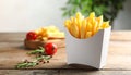 Delicious french fries in paper box on wooden table, space for text Royalty Free Stock Photo