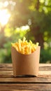Delicious french fries in paper box on wooden table, space for text Royalty Free Stock Photo