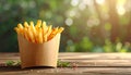 Delicious french fries in paper box on wooden table, space for text Royalty Free Stock Photo