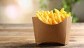 Delicious french fries in paper box on wooden table, space for text Royalty Free Stock Photo