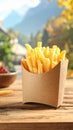 Delicious french fries in paper box on wooden table, space for text Royalty Free Stock Photo