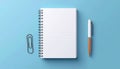 Open Notebook with Pen and Clip on Blue Background Royalty Free Stock Photo