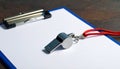 Referee Whistle and Blank Clipboard on Dark Background Royalty Free Stock Photo