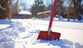 Red Snow Shovel Standing in Fresh Snow with Footprints Royalty Free Stock Photo