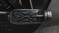 Ornate Dark Metal Motorcycle Footpeg with Intricate Tribal Design Royalty Free Stock Photo