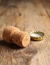 Cork of sparkling wine and muselet cap on wooden table, closeup. Space for text Royalty Free Stock Photo