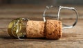 Cork of sparkling wine and muselet cap on wooden table, closeup. Space for text Royalty Free Stock Photo