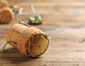 Cork of sparkling wine and muselet cap on wooden table, closeup. Space for text Royalty Free Stock Photo