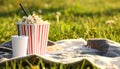 Popcorn and drink on blanket in open air cinema. Space for text Royalty Free Stock Photo