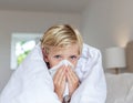 Sick Child Blowing Nose in Bed Royalty Free Stock Photo