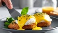 Fork Cutting into Eggs Benedict with Creamy Hollandaise Sauce Royalty Free Stock Photo