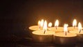 Many candle flames glowing on dark background. Close-up. Free space. Royalty Free Stock Photo