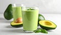 A glass of avocado smoothie is placed on a white surface, garnished with mint leaves. Royalty Free Stock Photo