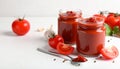 Jars of tasty tomato paste, spoon and ingredients on white table Royalty Free Stock Photo