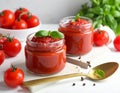 Jars of tasty tomato paste, spoon and ingredients on white table Royalty Free Stock Photo