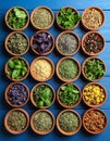 Many different herbs in bowls on blue wooden table Royalty Free Stock Photo