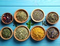 Many different herbs in bowls on blue wooden table Royalty Free Stock Photo