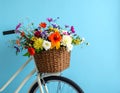 A bicycle with a basket of beautiful flowers on a light blue background. Royalty Free Stock Photo