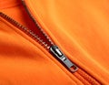 Orange sweatshirt with zipper as background, closeup view Royalty Free Stock Photo
