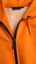 Orange sweatshirt with zipper as background, closeup view Royalty Free Stock Photo