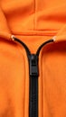 Orange sweatshirt with zipper as background, closeup view Royalty Free Stock Photo