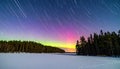 Aurora Borealis Over Frozen Lake with Star Trails Royalty Free Stock Photo