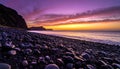 Dramatic Purple and Orange Sunset over a Pebble Beach Royalty Free Stock Photo