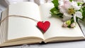 Red wooden heart pendant, an open diary with clean pages and flowers. Romantic concept Royalty Free Stock Photo