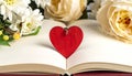 Red wooden heart pendant, an open diary with clean pages and flowers. Romantic concept Royalty Free Stock Photo