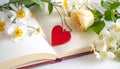 Red wooden heart pendant, an open diary with clean pages and flowers. Romantic concept Royalty Free Stock Photo