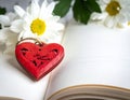 Red wooden heart pendant, an open diary with clean pages and flowers. Romantic concept Royalty Free Stock Photo