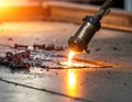 Industrial gas cutting torch with flame cutting steel plate. Metalwork fabrication in a factory with hot sparks and molt Royalty Free Stock Photo