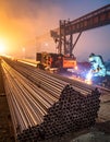 Welder fabricating steel rebar at night in a heavy industry plant with a gantry crane. Royalty Free Stock Photo