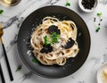 luxurious italian truffle pasta on a matte black plate with shaved black truffles and parmesan cheese Royalty Free Stock Photo