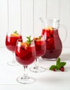 Glasses and jug of Red Sangria on white wooden table Royalty Free Stock Photo