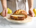 Woman with slice of pear bread at white marble table, closeup. Homemade cake Royalty Free Stock Photo