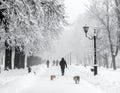 After a night of snow blizzard foggy morning silhouettes of passers citizens walking Royalty Free Stock Photo