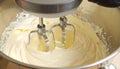 Electric mixer blending a creamy mixture in a stainless steel bowl. Royalty Free Stock Photo