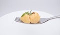 Two small dumplings rest on a silver fork against a white background. Royalty Free Stock Photo