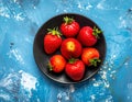 Fresh strawberries on a small black plate against a blue plaster design board. Royalty Free Stock Photo