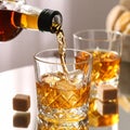 Pouring tasty whiskey from bottle into glass at mirror table, closeup Royalty Free Stock Photo