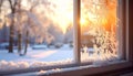 Frosty winter window with snow and golden sunrise light. Cozy home view of a beautiful frozen morning landscape. Royalty Free Stock Photo