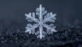Snowflake macro of a real ice crystal. Extreme close-up of a beautiful, symmetrical snow crystal on a dark background. Royalty Free Stock Photo