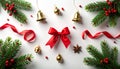 Christmas flat lay background with festive decorations, fir branches, red ribbon bow, and golden bells on white. Royalty Free Stock Photo
